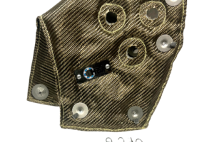 A piece of cloth with several holes and four small metal clips.