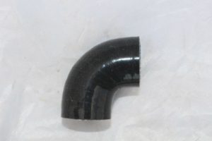 A black pipe sitting on top of a white sheet.