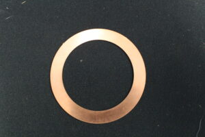 A copper washer sitting on top of a table.
