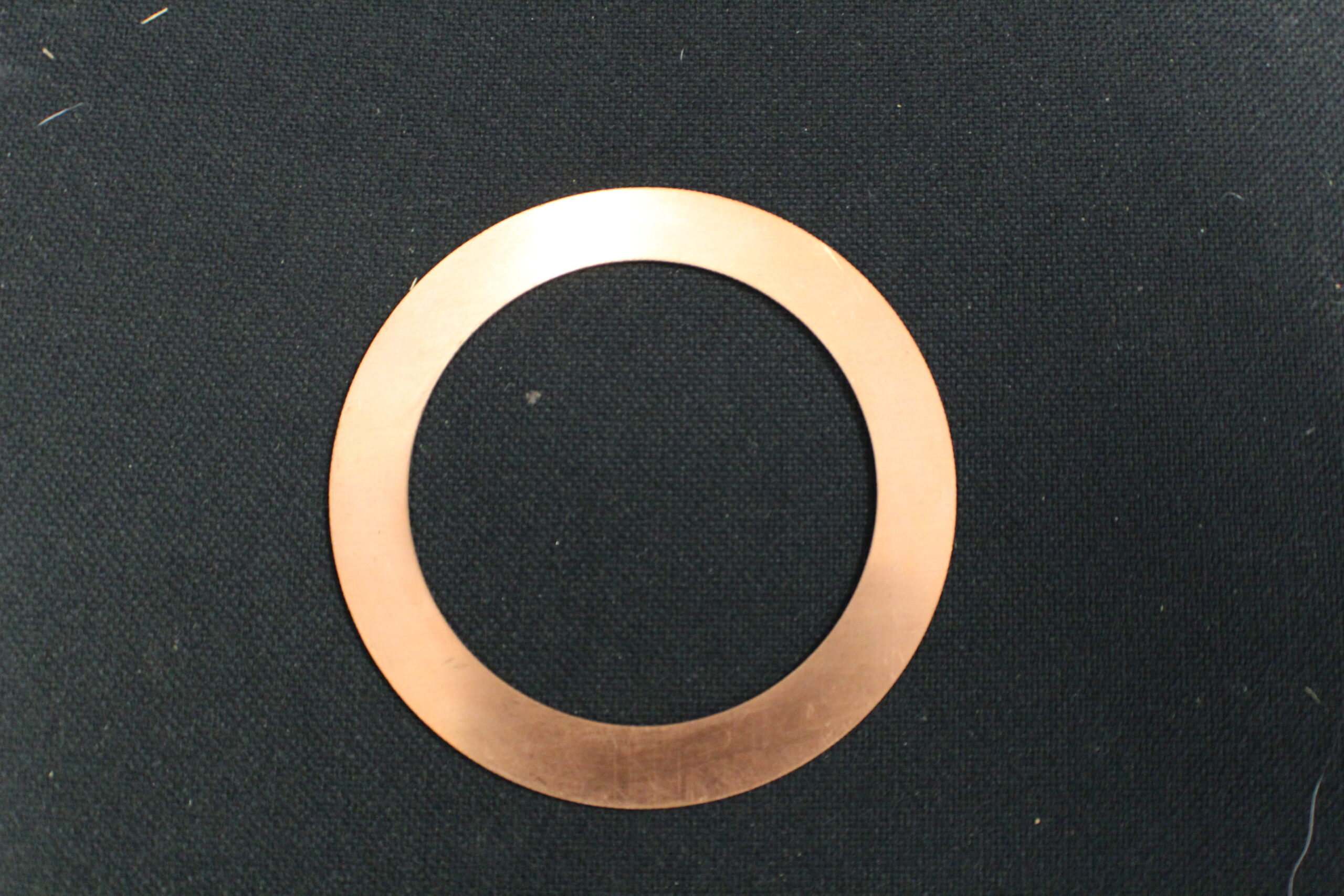 A copper washer sitting on top of a table.